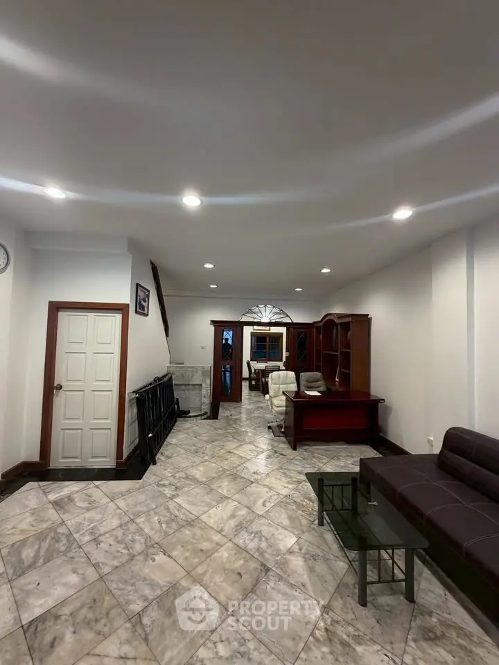 Spacious living room with elegant marble flooring and modern furniture, perfect for family gatherings.