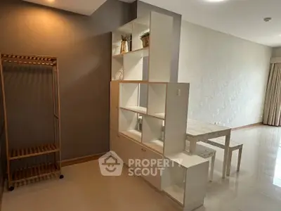 Modern open-plan living area with stylish shelving and dining set