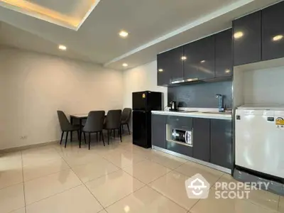 Modern kitchen with sleek cabinetry and dining area in open layout apartment