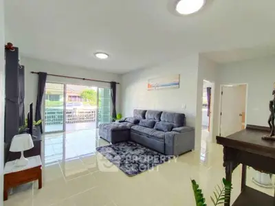 Spacious living room with modern decor and large sliding doors leading to a balcony.