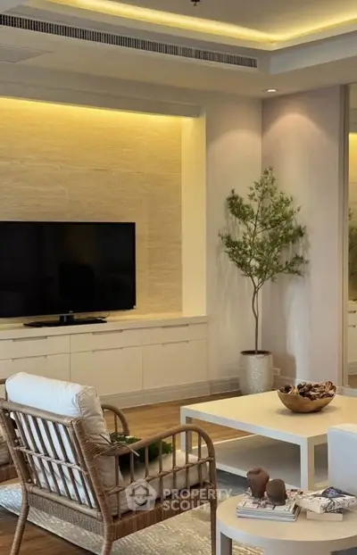Elegant living room with modern decor, featuring a flat-screen TV, stylish furniture, and ambient lighting.
