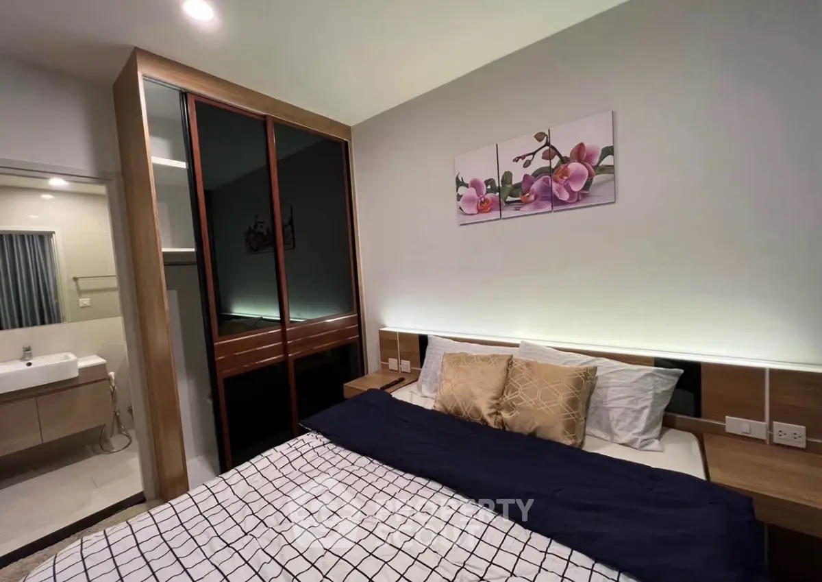 Modern bedroom with stylish decor and ensuite bathroom in a cozy apartment.