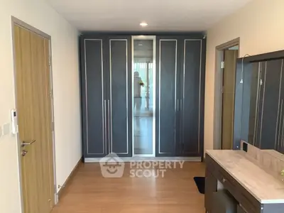 Spacious bedroom with modern wardrobe and wooden flooring