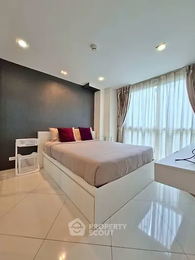 Modern bedroom with large windows and stylish decor in a high-rise apartment.