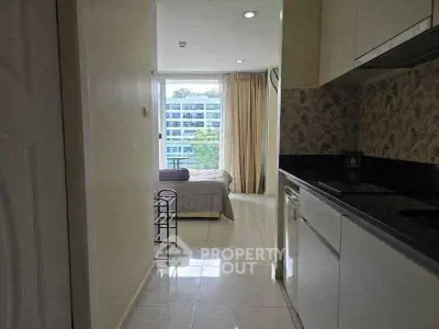 Modern apartment interior with sleek kitchen and cozy bedroom view.