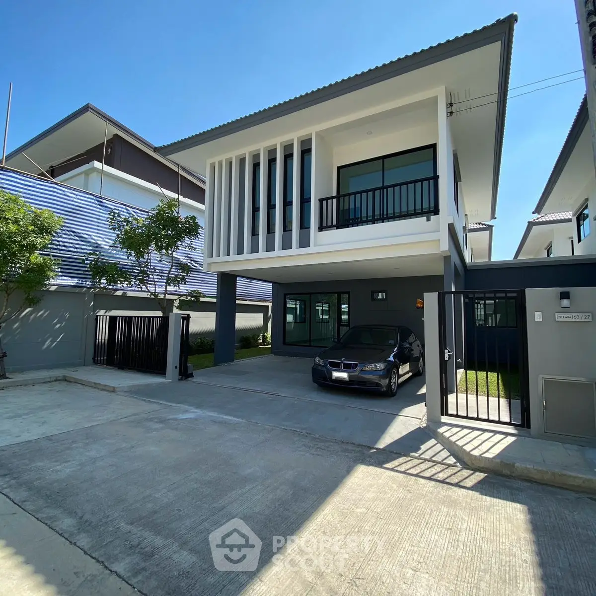 Modern two-story house with carport and sleek architectural design
