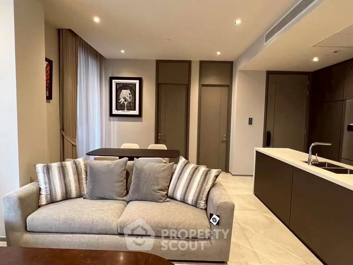 Modern living room with stylish sofa and open kitchen layout, perfect for contemporary living.