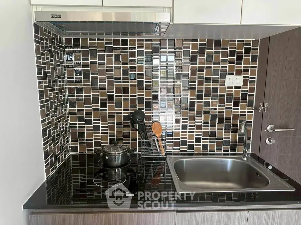 Modern kitchen with sleek black countertop and mosaic tile backsplash