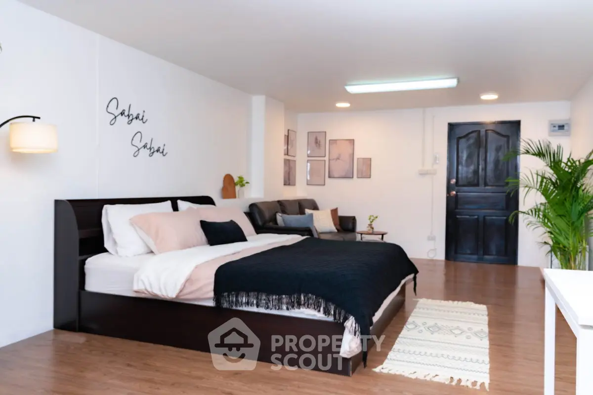 Spacious bedroom with modern decor and cozy seating area