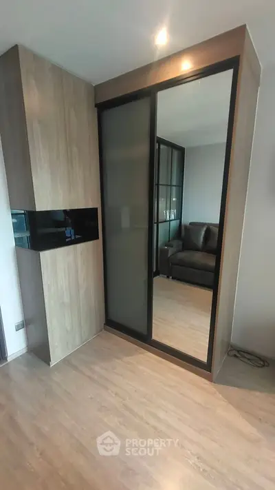 Modern living room with sleek wooden flooring and stylish glass partition