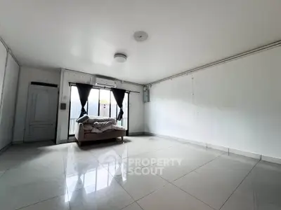 Spacious minimalist living room with large windows and sleek tile flooring