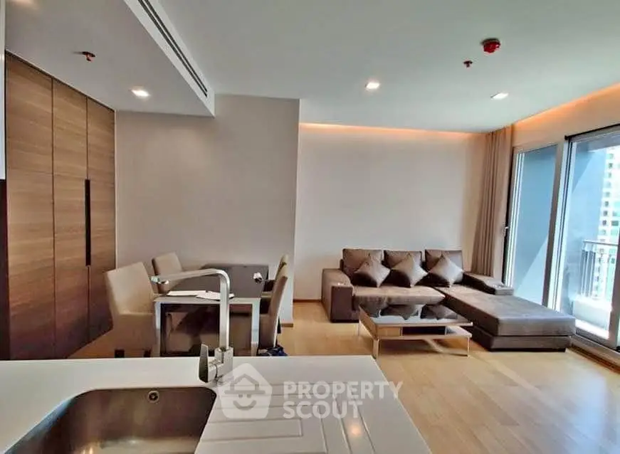 Modern living room with elegant furniture and balcony view in a stylish apartment.