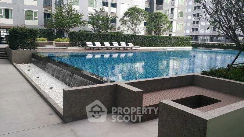 Luxurious condominium pool area with modern design and ample lounging space.