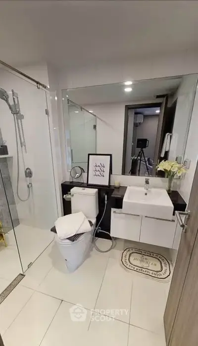 Modern bathroom with glass shower, sleek vanity, and elegant decor