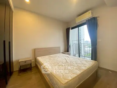 Cozy bedroom with balcony access and modern air conditioning unit.
