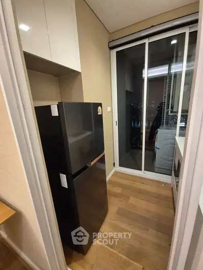 Modern kitchen with sleek black fridge and sliding glass door