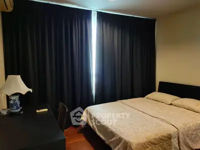 Cozy bedroom with elegant decor and dark curtains for a serene ambiance.