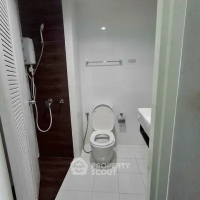Modern bathroom with sleek design featuring a shower and toilet in a compact space.