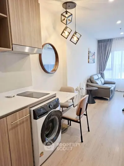 Modern living room with washing machine and stylish lighting in a cozy apartment.