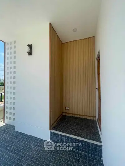 Modern minimalist entrance with wooden accents and tiled flooring
