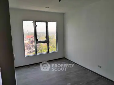 Spacious empty room with large window offering panoramic city view