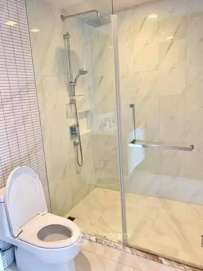 Modern bathroom with glass shower and sleek white fixtures