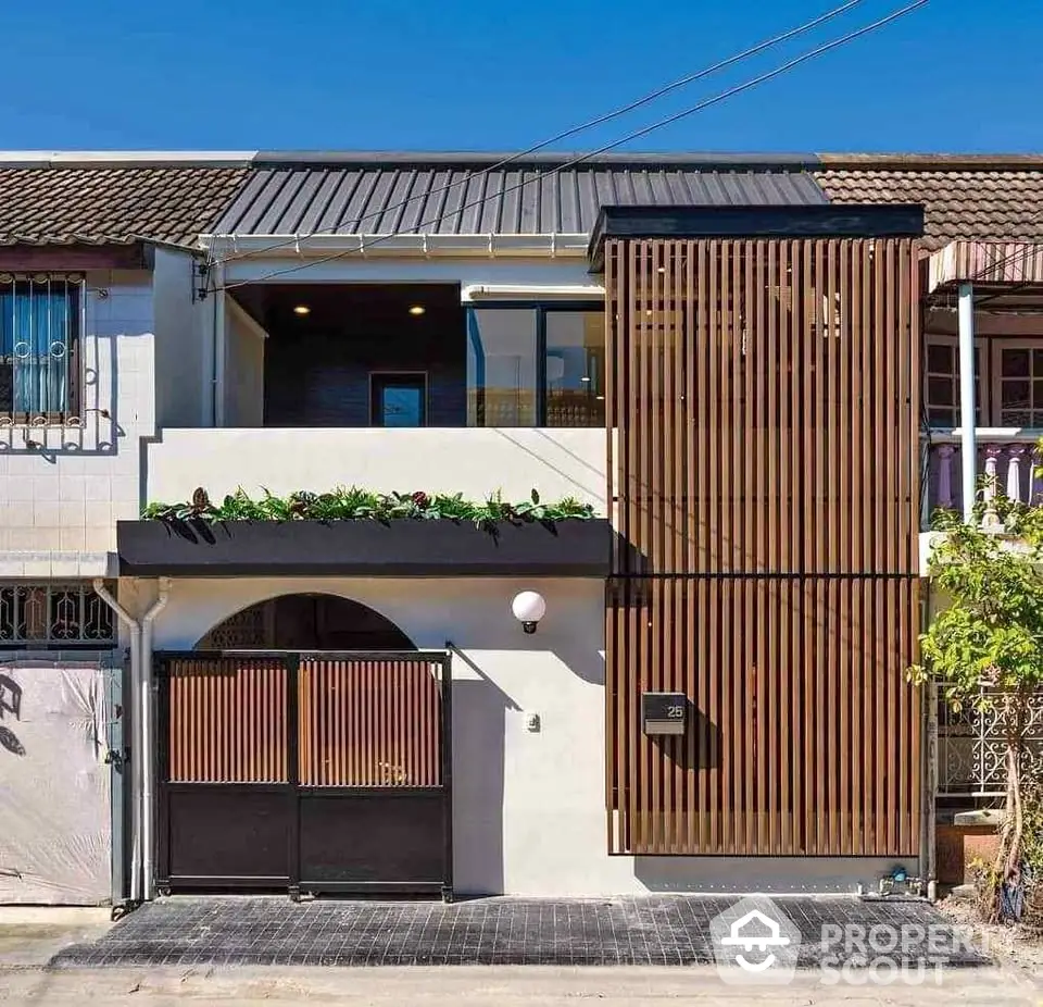 Modern townhouse with wooden facade and balcony in urban setting