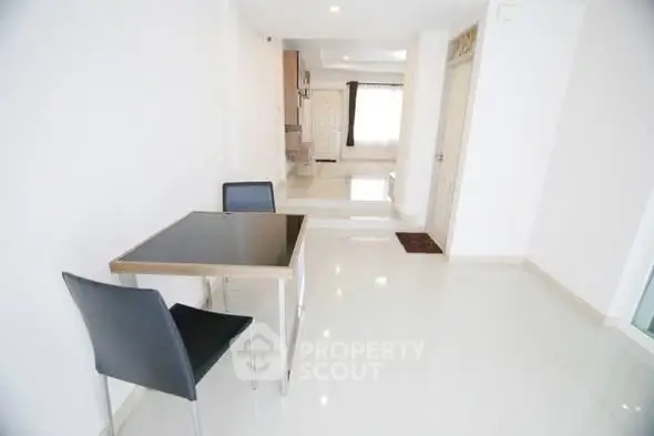 Spacious modern dining area with sleek table and chairs, bright white interior, and open layout.