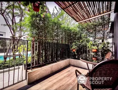 Charming balcony with lush greenery and pool view, perfect for relaxation.