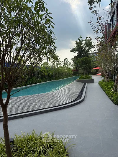 Luxurious outdoor pool area with lush greenery and modern design, perfect for relaxation and leisure.