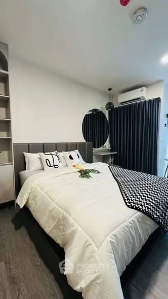 Modern bedroom with stylish decor and cozy bedding in a contemporary apartment.