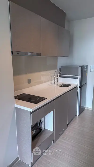 Modern kitchen with sleek cabinetry and built-in appliances in a compact layout.