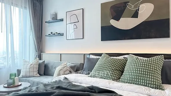 Stylish modern bedroom with cozy seating and abstract art