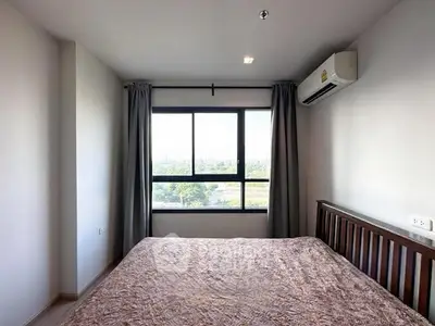 Cozy bedroom with large window offering scenic views and natural light.