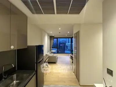 Modern open-layout apartment with sleek kitchen and spacious living area leading to a balcony.