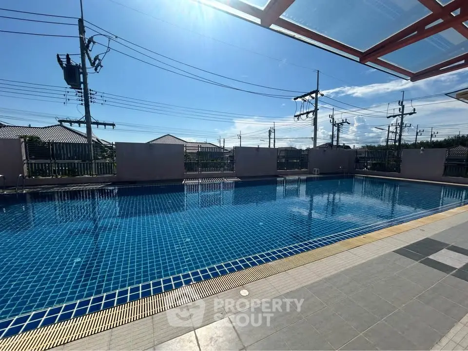 Stunning outdoor pool with clear blue water and sunny sky, perfect for relaxation and leisure.