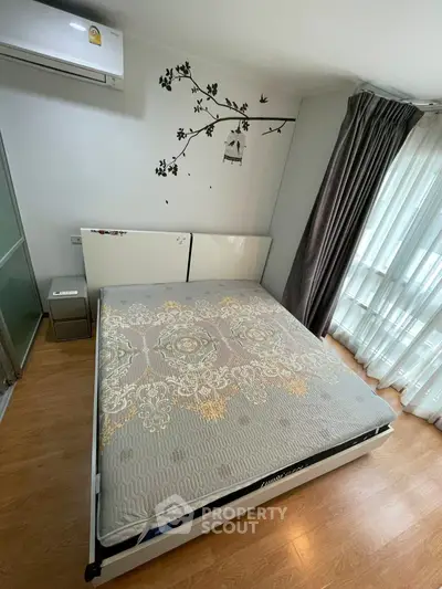 Cozy bedroom with stylish decor and natural light, featuring a comfortable bed and elegant curtains.