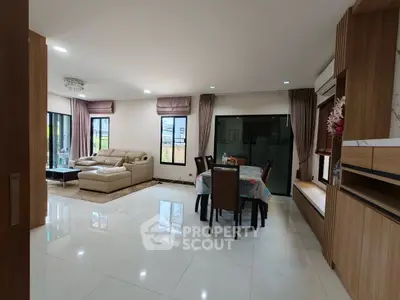 Spacious modern living room with elegant dining area and large windows for natural light.