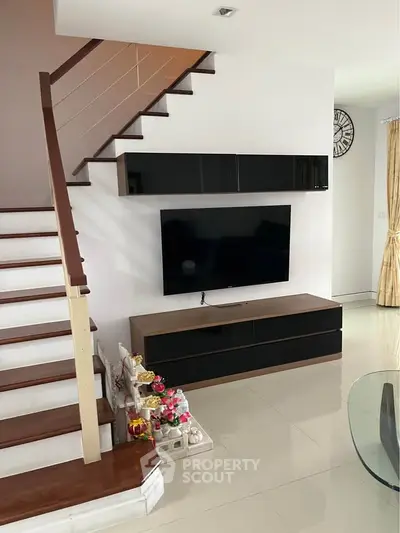 Modern living room with sleek TV unit and stylish staircase, perfect for contemporary living.