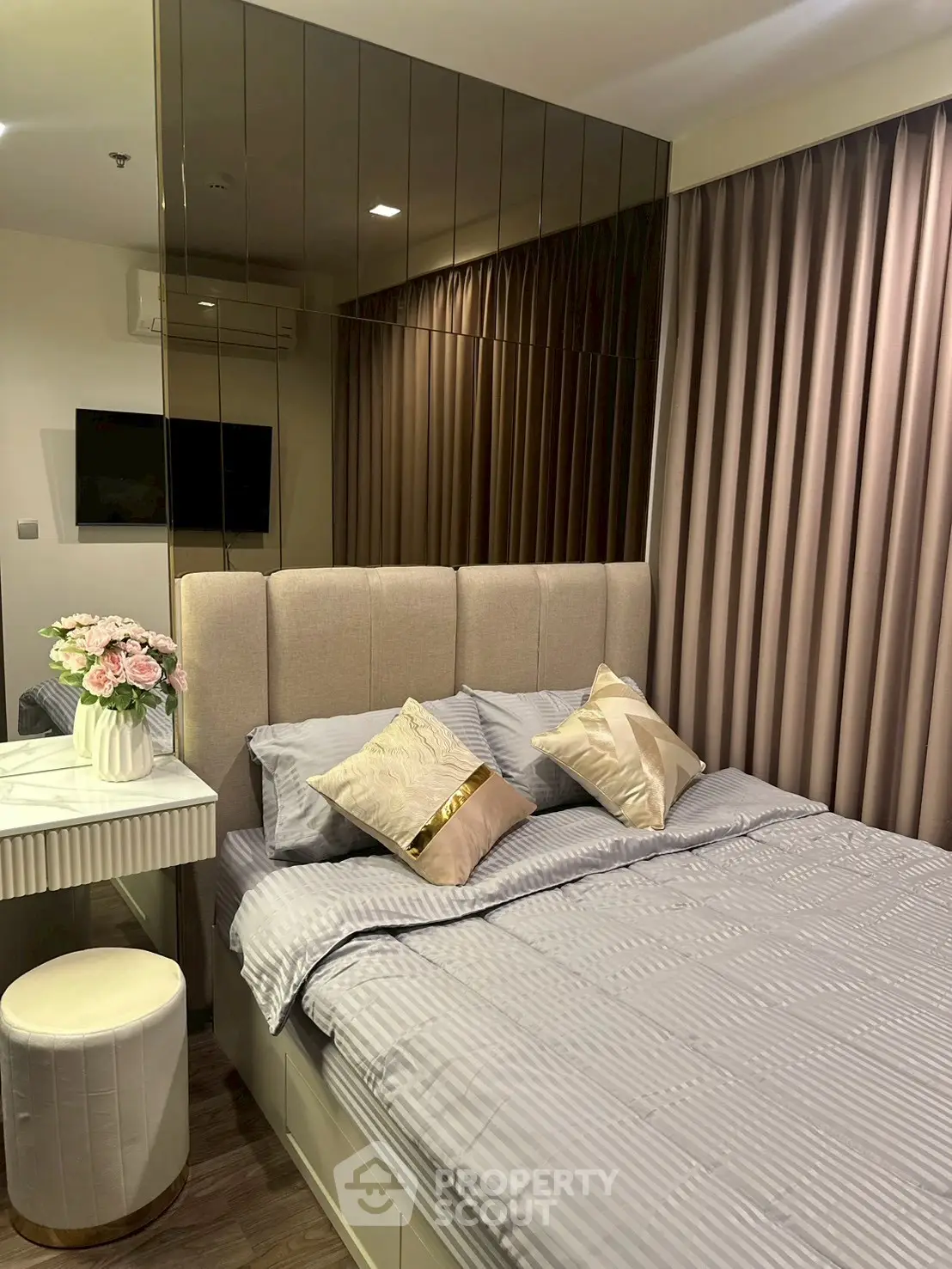 Luxurious bedroom with elegant decor and plush bedding in modern apartment.