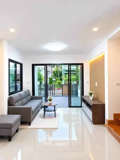 Modern living room with sleek design and large glass doors opening to a patio.