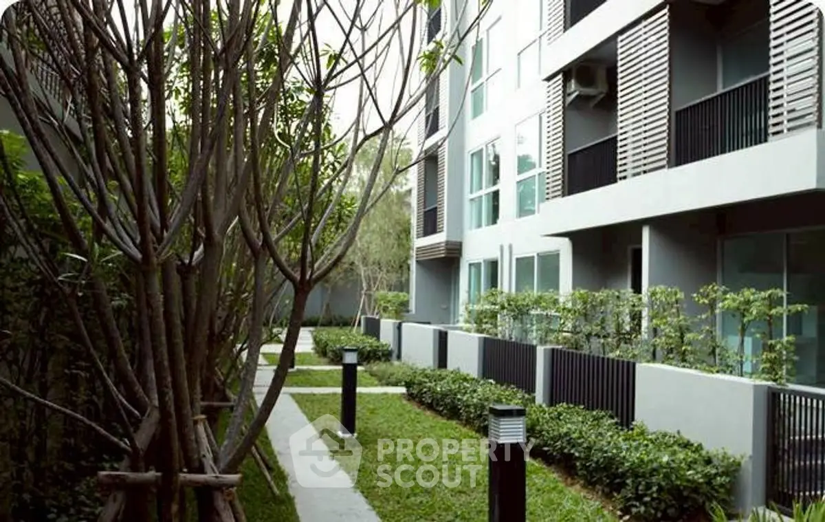 Modern apartment building with lush garden and sleek exterior design