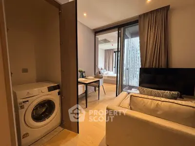 Modern apartment interior with washing machine, cozy living area, and balcony view.
