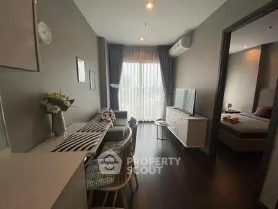 Modern living room with dining area and bedroom view, featuring stylish decor and natural light.