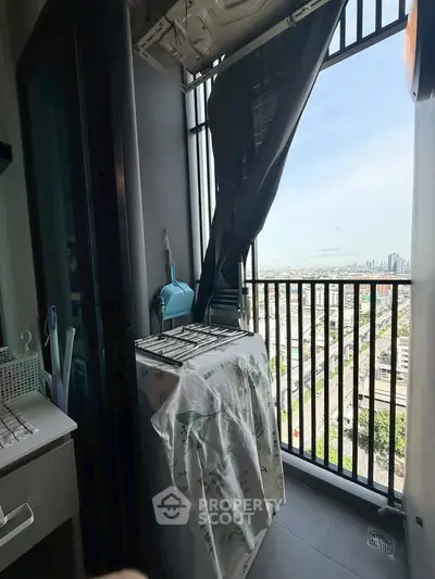 Compact balcony with city view, featuring laundry area and modern railing design.