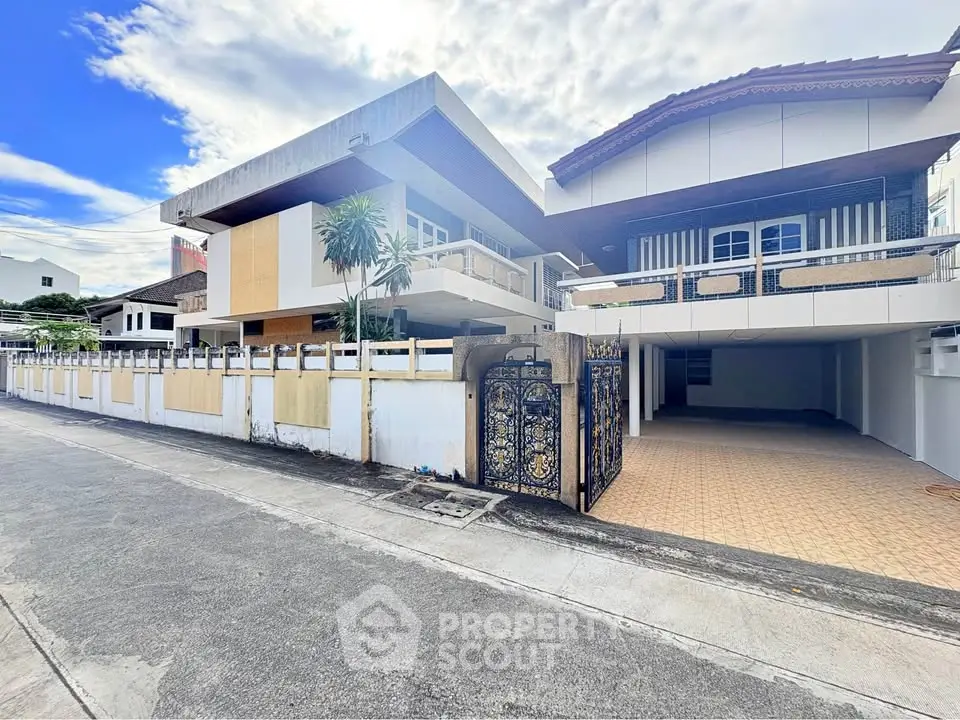 Modern residential building with spacious driveway and stylish gate