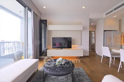 Modern living room with sleek furniture and large windows offering city views