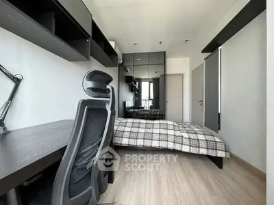 Modern compact bedroom with built-in desk and shelving, featuring a comfortable single bed and sleek dark accents, ideal for urban living.