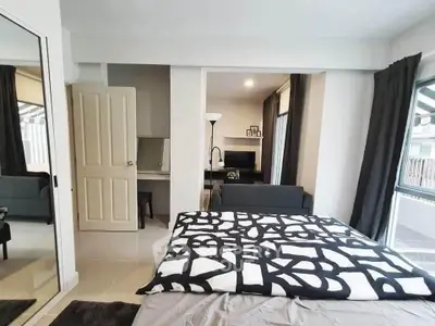 Modern bedroom with stylish decor and open layout leading to a cozy living area.