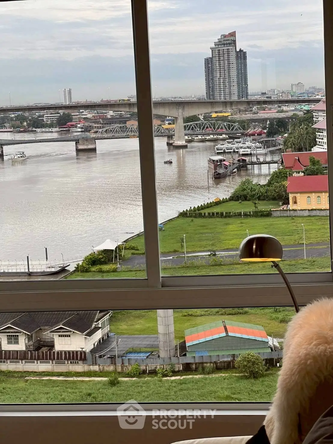 Stunning river view from a modern apartment window with cityscape backdrop.